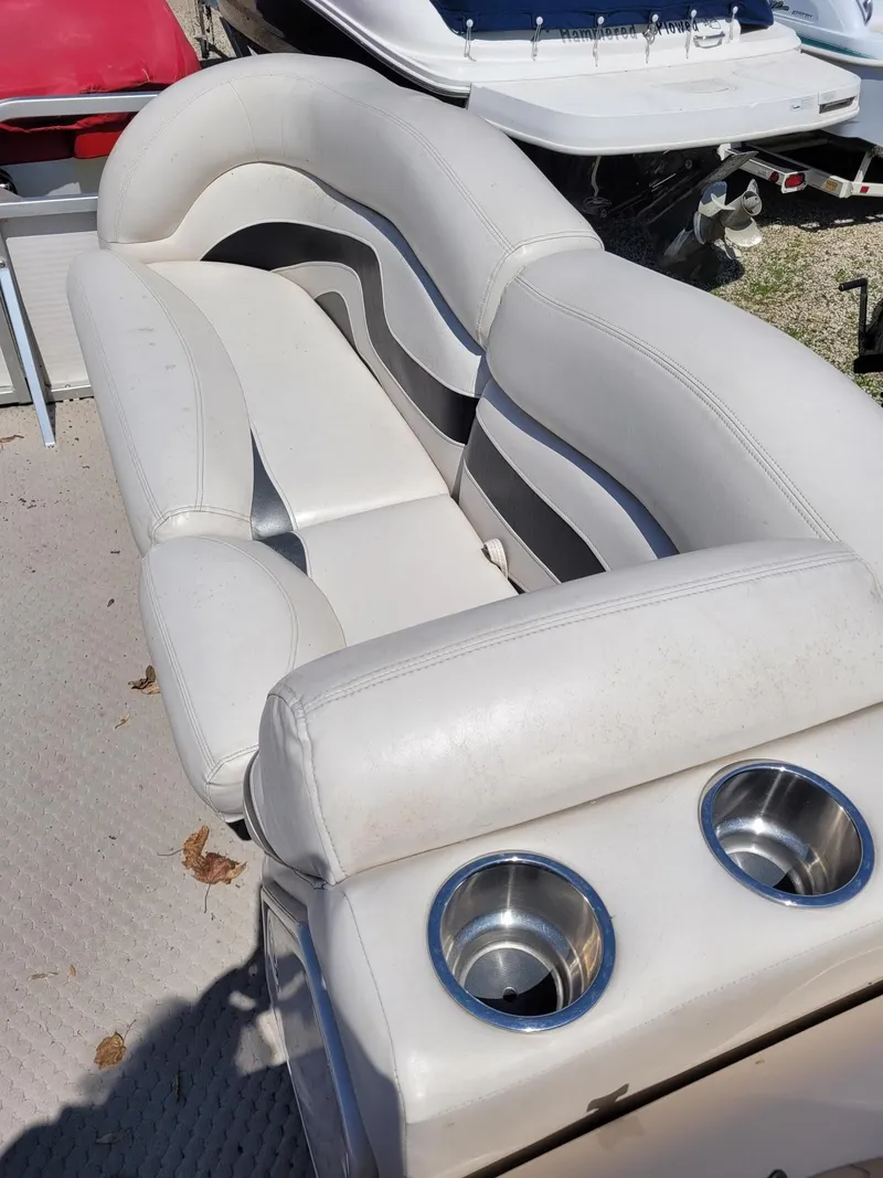 Slide: The Image of 2008 Manitou 20 Oasis boat with white and gray seating and cup holders. - 14