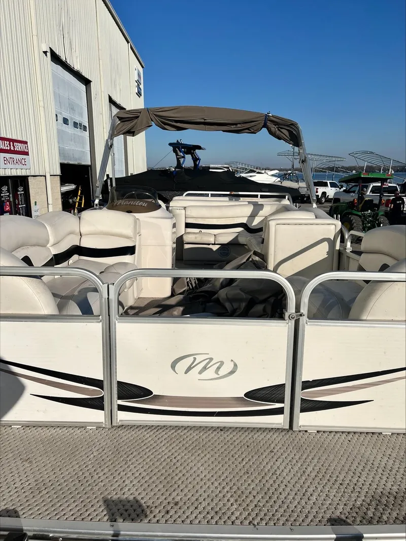Slide: The Image of 2008 Manitou 20 Oasis pontoon boat at a marina with a service center. - 16