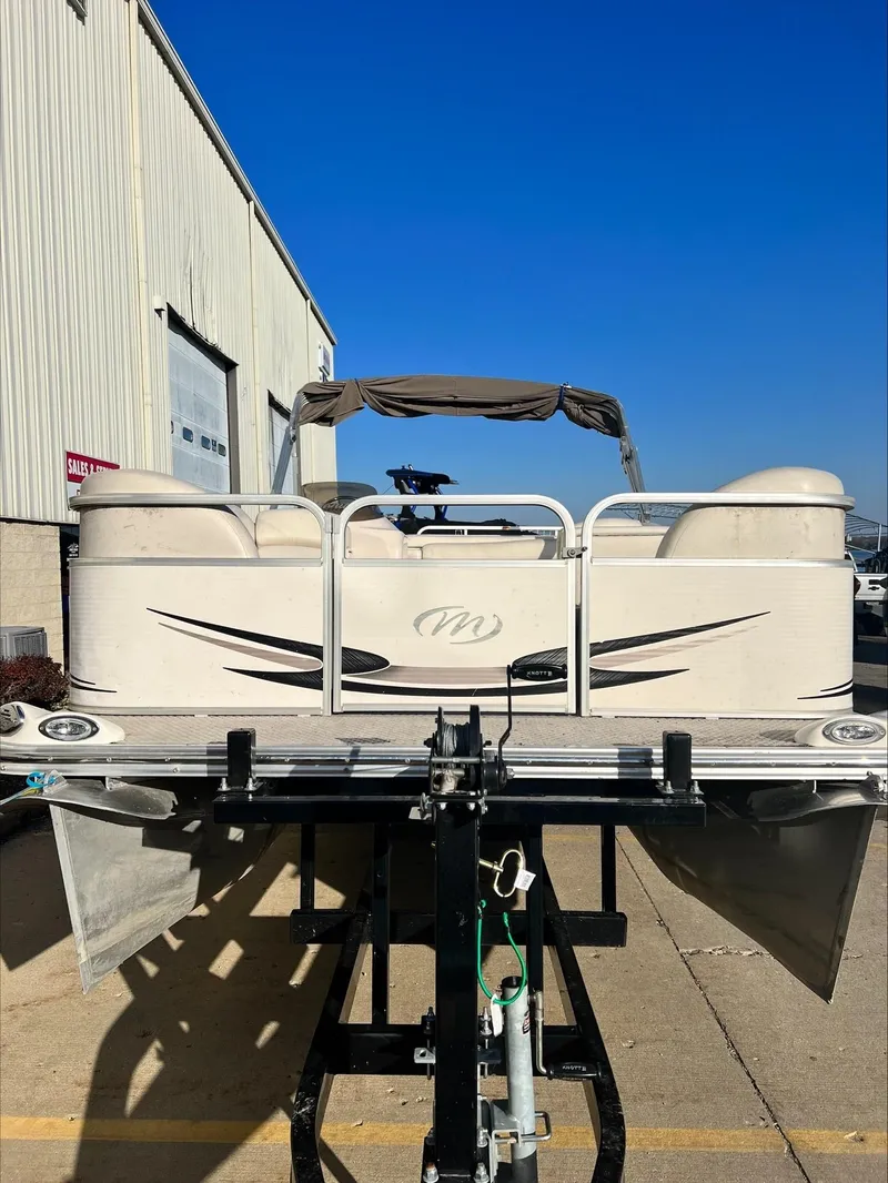 Slide: The Image of 2008 Manitou 20 Oasis pontoon boat on a trailer outside a warehouse. - 17