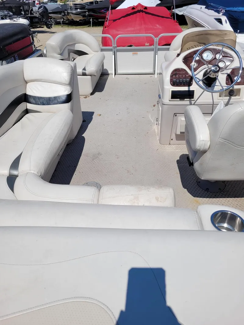 Slide: The Image of Interior of a 2008 Manitou 20 Oasis pontoon boat with white seating and steering console. - 4