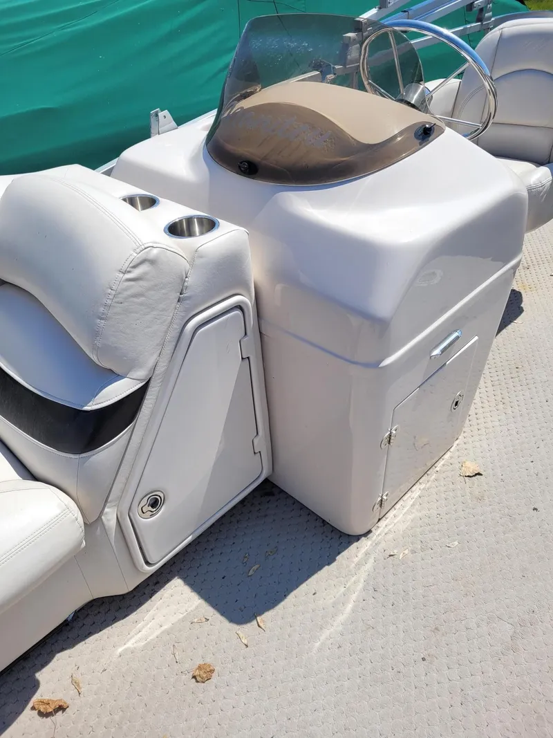 Slide: The Image of 2008 Manitou 20 Oasis boat console and seating area with cup holders. - 7