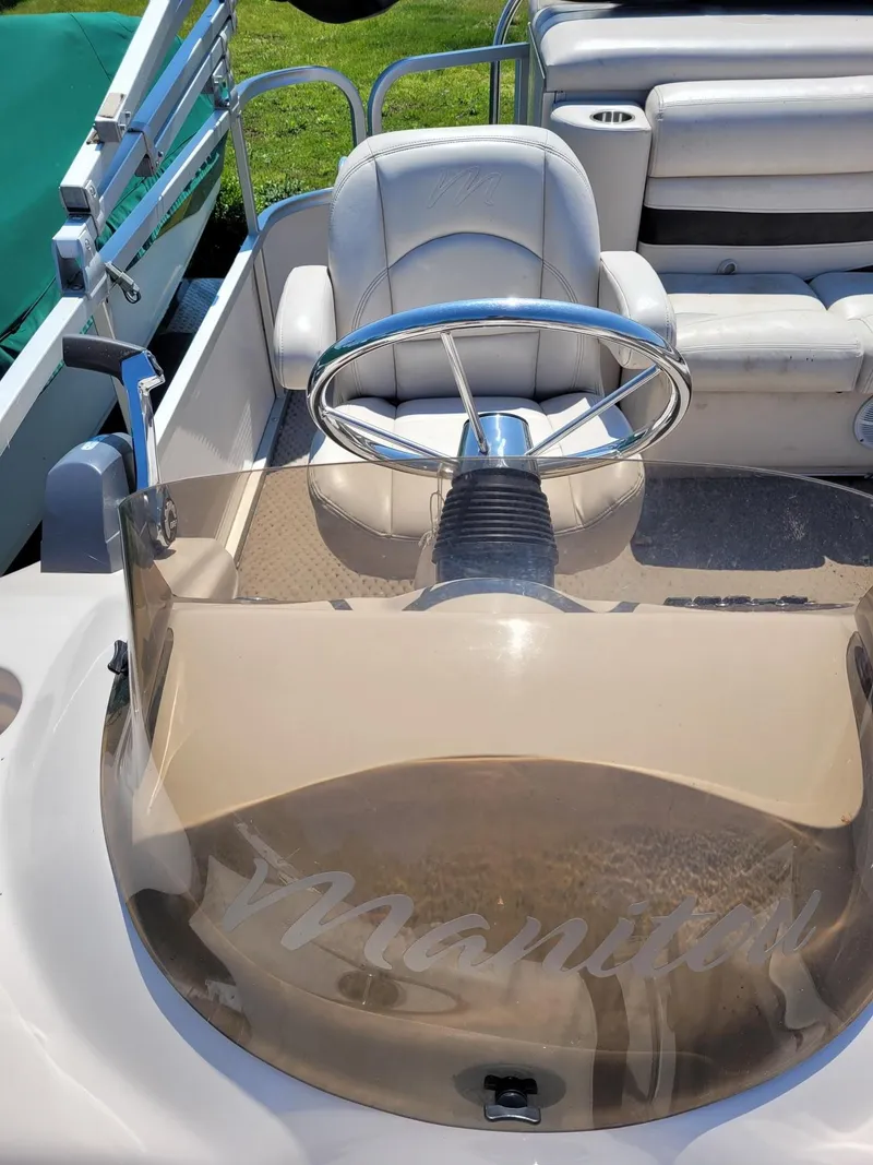 Slide: The Image of 2008 Manitou 20 Oasis boat steering console and seating area. - 8