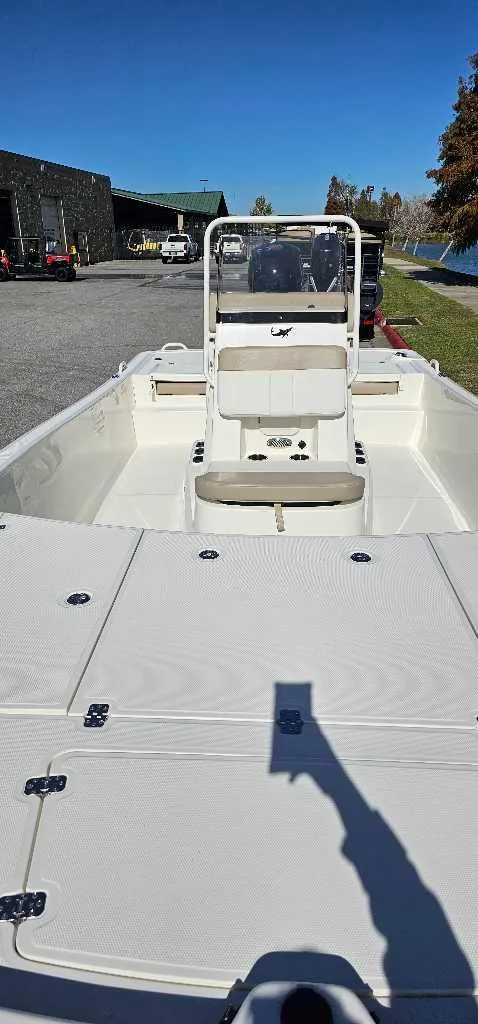 Slide: The Image of 2024 Mako Pro Skiff 19 CC boat, center console, docked outdoors. - 2