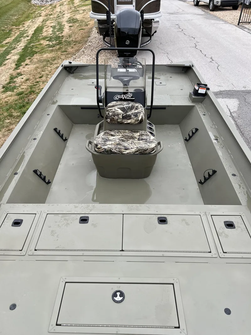 Slide: The Image of 2024 Tracker Grizzly 2072 CC boat interior with camo seats and storage compartments. - 10