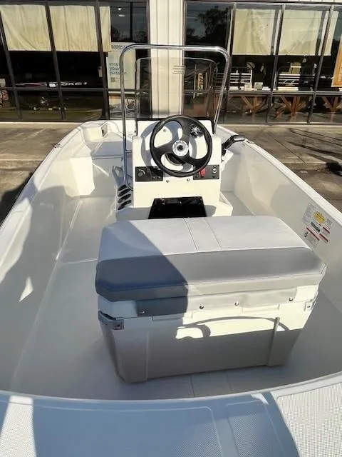 Slide: The Image of 2024 Mako Pro Skiff 15 CC boat interior with steering console and seating. - 4