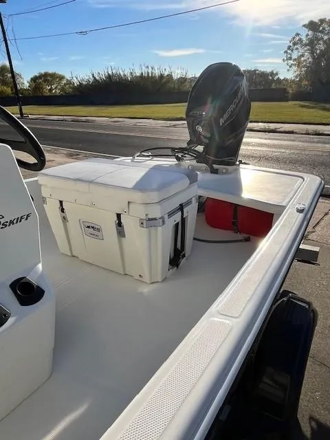 Slide: The Image of 2024 Mako Pro Skiff 15 CC boat with outboard motor and cooler. - 6