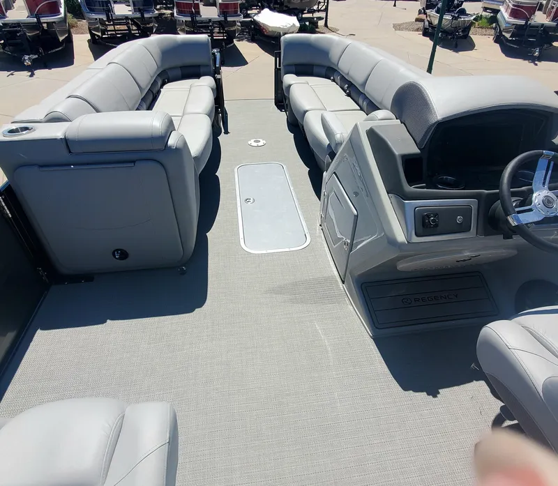 Slide: The Image of 2024 Regency 250 LE3 Sport pontoon boat interior with spacious seating and modern helm. - 3
