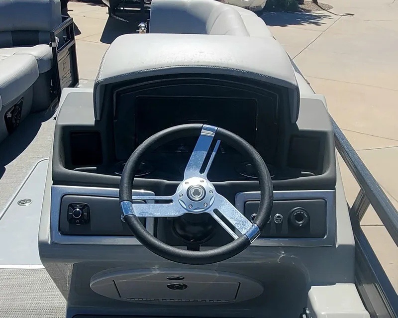 Slide: The Image of 2024 Regency 250 LE3 Sport boat dashboard with steering wheel and control panel. - 4