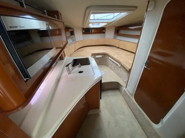 Slide: The Image of Interior of 2011 Sea Ray 280 Sundancer with kitchenette and seating area. - 11
