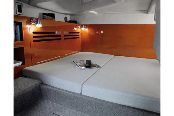 Slide: The Image of 2011 Sea Ray 280 Sundancer cabin interior with bed and reading materials. - 12