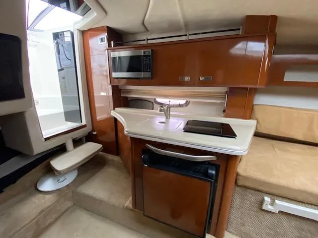 Slide: The Image of 2011 Sea Ray 280 Sundancer interior kitchen with microwave, sink, and mini-fridge. - 15