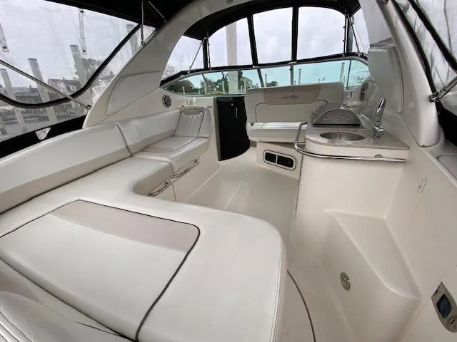 Slide: The Image of 2011 Sea Ray 280 Sundancer interior with white seating and kitchenette. - 4