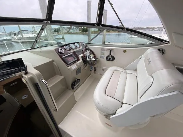 Slide: The Image of 2011 Sea Ray 280 Sundancer helm with white leather seating and modern controls. - 7