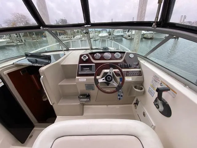 Slide: The Image of 2011 Sea Ray 280 Sundancer helm with steering wheel, gauges, and navigation equipment. - 8