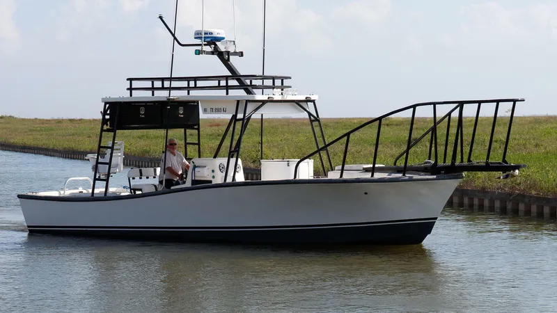 The Image of 1997 Custom 31 Center Console boat cruising on a calm waterway. - 1