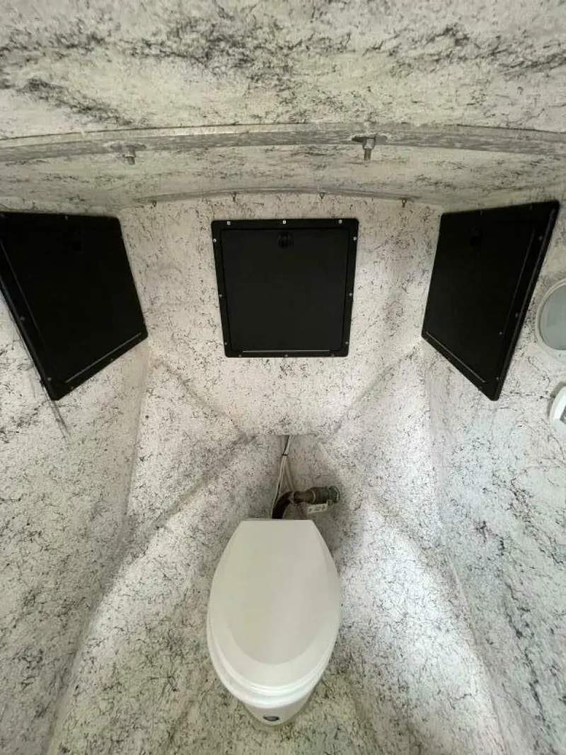 Slide: The Image of 1997 Custom 31 Center Console boat interior with marine toilet and storage compartments. - 11