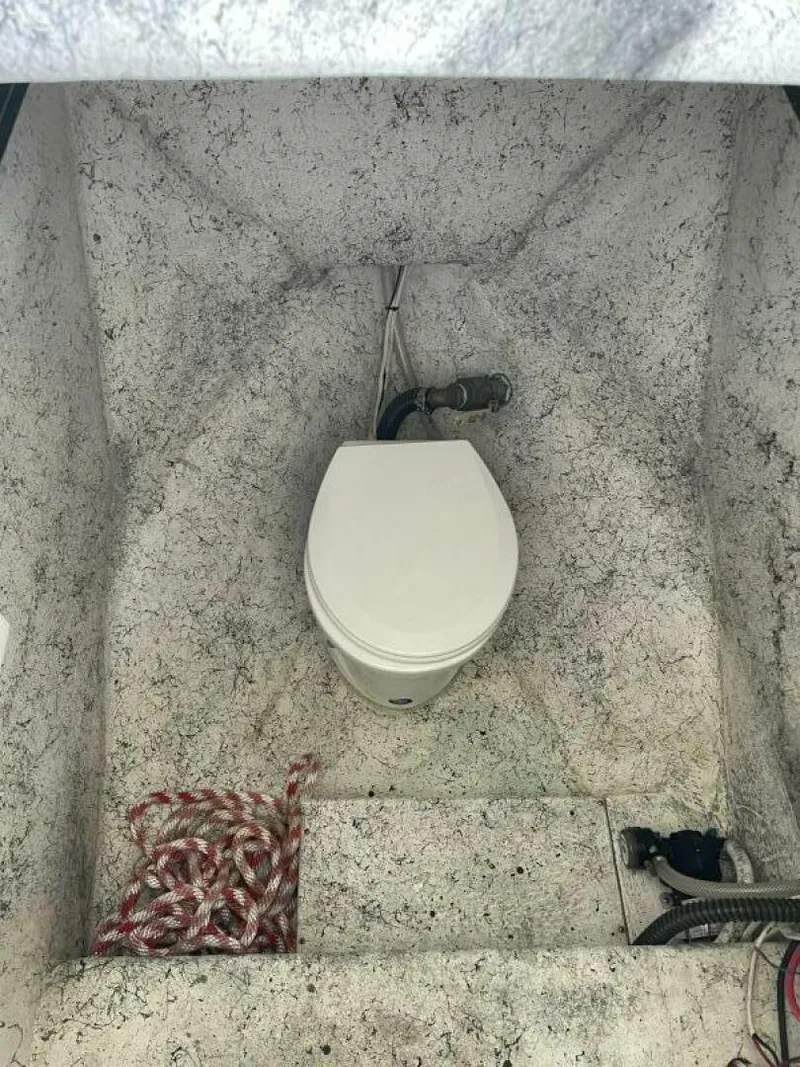 Slide: The Image of 1997 Custom 31 Center Console boat interior with toilet and rope. - 15