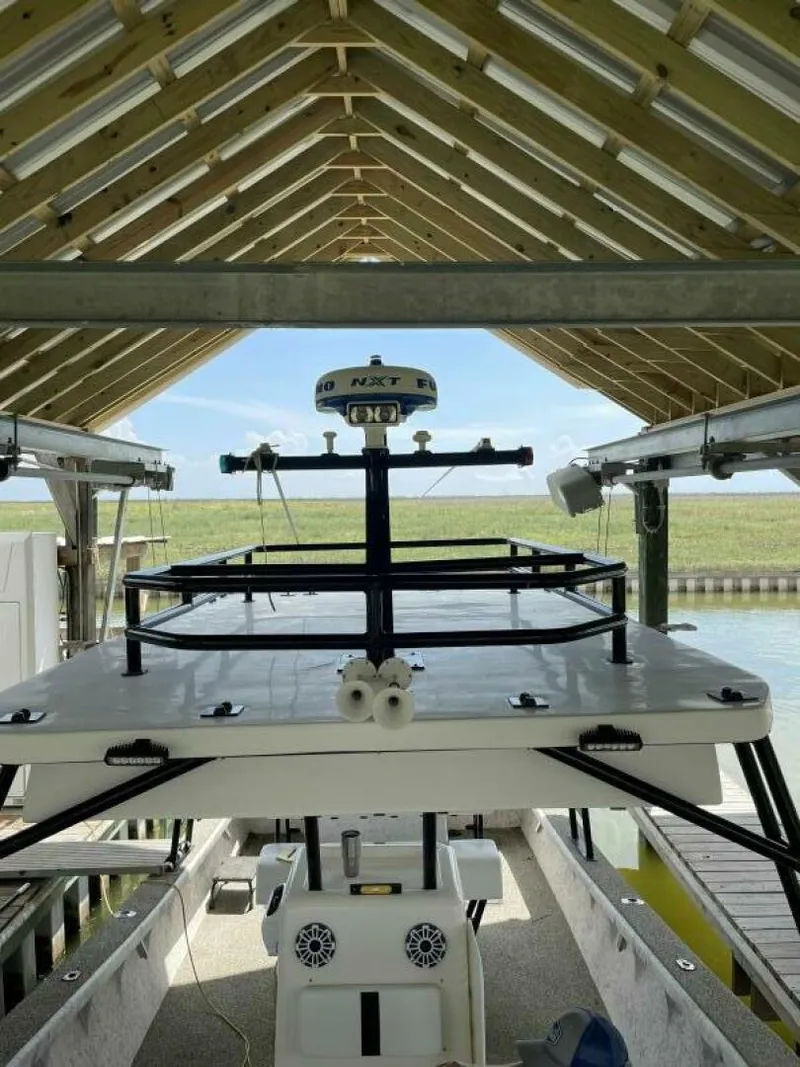 Slide: The Image of 1997 Custom 31 Center Console boat docked under a wooden canopy. - 21