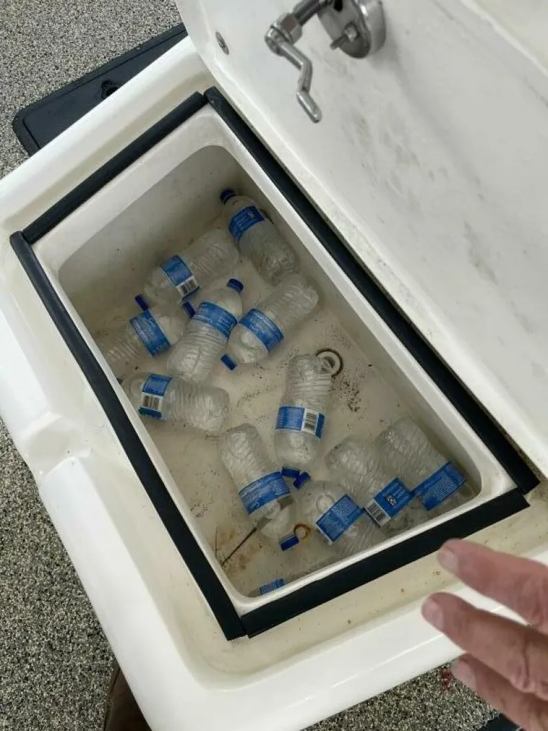 Slide: The Image of Cooler with empty water bottles on a 1997 Custom 31 Center Console boat. - 26