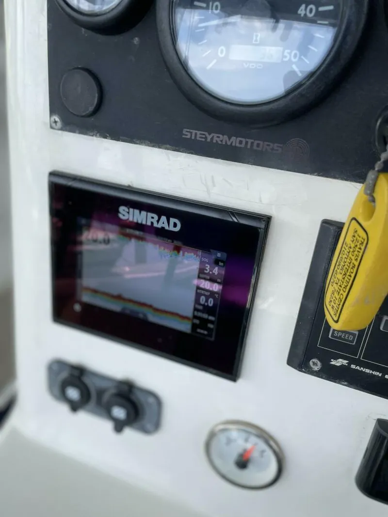 Slide: The Image of Close-up of 1997 Custom 31 Center Console boat dashboard with Simrad display. - 4