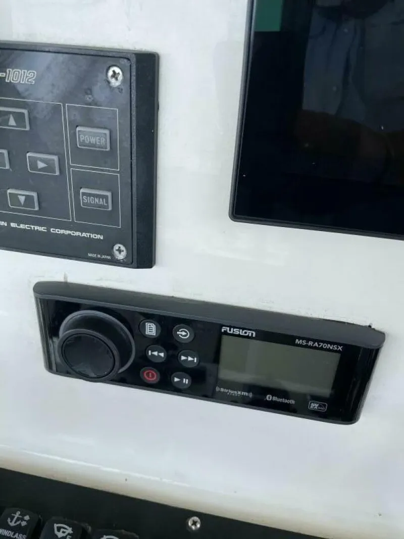 Slide: The Image of 1997 Custom 31 Center Console boat control panel with Fusion stereo system. - 5