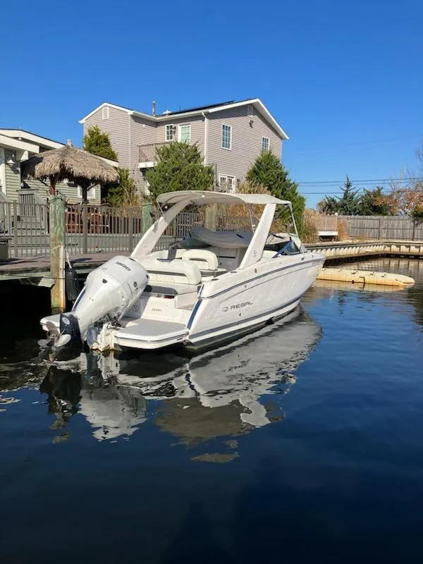 The Image of 2020 Regal 26 OBX boat docked near waterfront homes. - 0