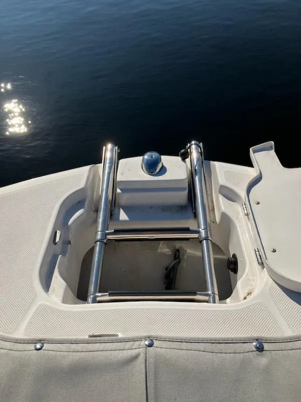 Slide: The Image of 2020 Regal 26 OBX boat with retracted swim ladder on calm water. - 12