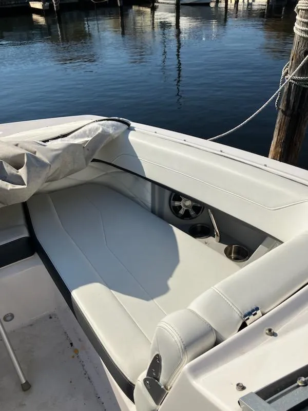 Slide: The Image of 2020 Regal 26 OBX boat with white seating at a marina. - 15