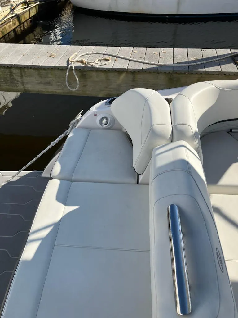 Slide: The Image of 2020 Regal 26 OBX boat with white leather seating docked at marina. - 21