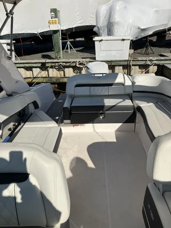 Slide: The Image of 2020 Regal 26 OBX boat interior with white seating and dock background. - 5