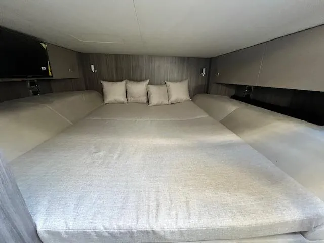 Slide: The Image of 2024 Sea Ray SLX 400 OB cabin with spacious bed and modern interior design. - 10