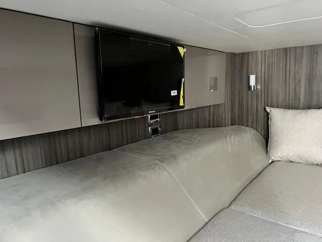 Slide: The Image of Interior cabin of 2024 Sea Ray SLX 400 OB with TV and modern decor. - 11