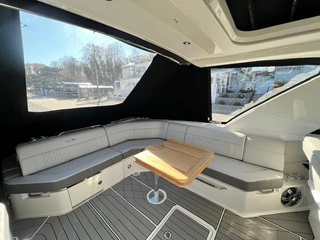 Slide: The Image of Luxurious interior of 2024 Sea Ray SLX 400 OB with elegant seating and wooden table. - 18