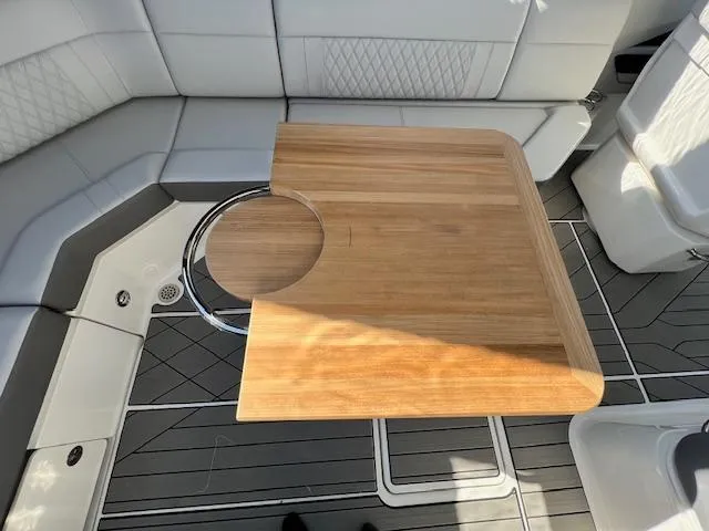 Slide: The Image of 2024 Sea Ray SLX 400 OB interior with wooden table and cushioned seating. - 21