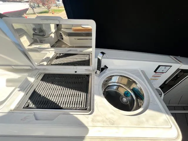 Slide: The Image of 2024 Sea Ray SLX 400 OB boat kitchen with grill and sink. - 28