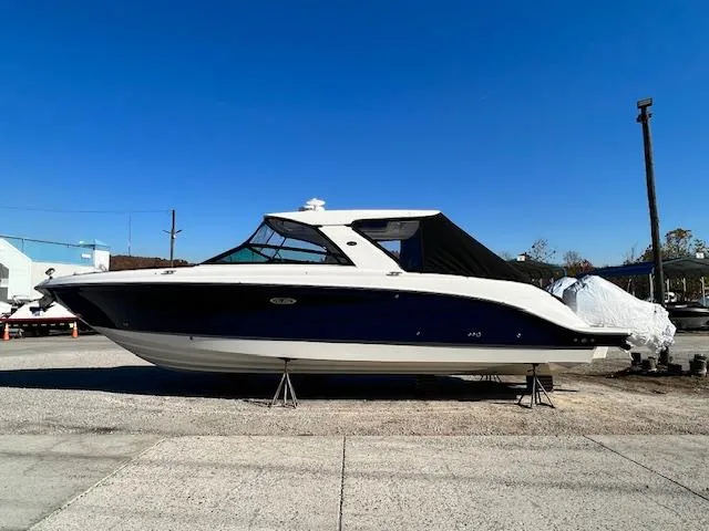 Slide: The Image of 2024 Sea Ray SLX 400 OB boat on a dry dock under a clear blue sky. - 4