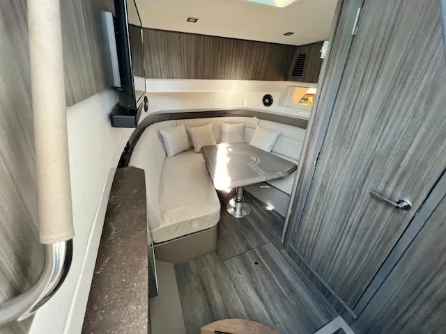 Slide: The Image of 2024 Sea Ray SLX 400 OB cabin interior with modern seating and table. - 5