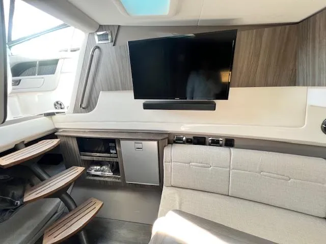 Slide: The Image of 2024 Sea Ray SLX 400 OB interior with TV, seating, and storage. - 7
