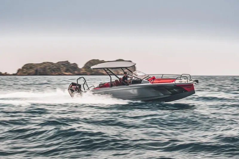 Slide: The Image of 2024 BRABUS SHADOW 300 CT speeding on the ocean near rocky islands. - 2