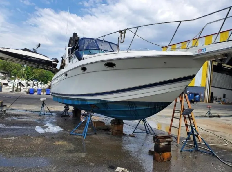 The Image of 2000 Formula 31 PC boat on stands in a marina for maintenance. - 0