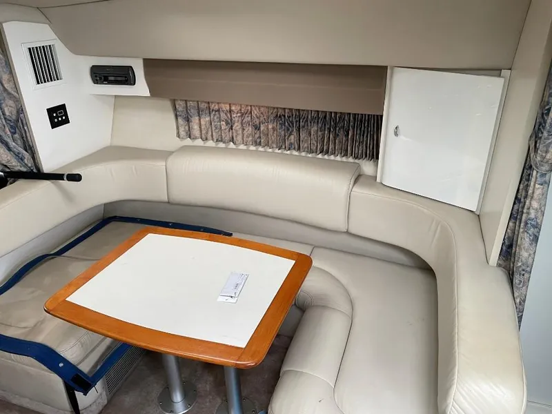 Slide: The Image of Interior of 2000 Formula 31 PC boat with beige leather seating and wooden table. - 9