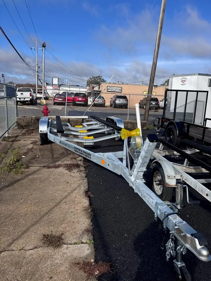 Slide: The Image of 1963 Chris-Craft Sportsman boat trailer parked outdoors on asphalt near industrial buildings. - 18