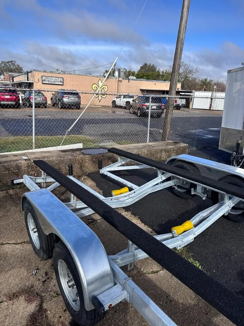 Slide: The Image of 1963 Chris-Craft Sportsman boat trailer parked in a lot with cars and buildings. - 19