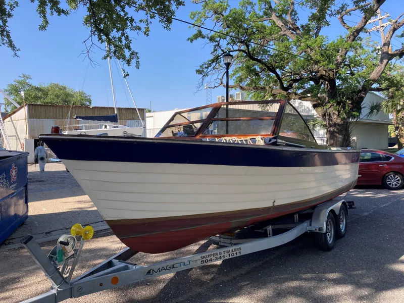 Slide: The Image of 1963 Chris-Craft Sportsman boat on trailer, parked outdoors under trees. - 4