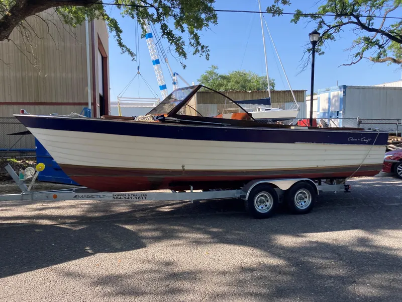 Slide: The Image of 1963 Chris-Craft Sportsman boat on trailer, parked outdoors under trees. - 5