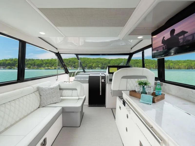 Slide: The Image of 2024 Regal 36 XO boat docked at night with vibrant purple lighting. - 2