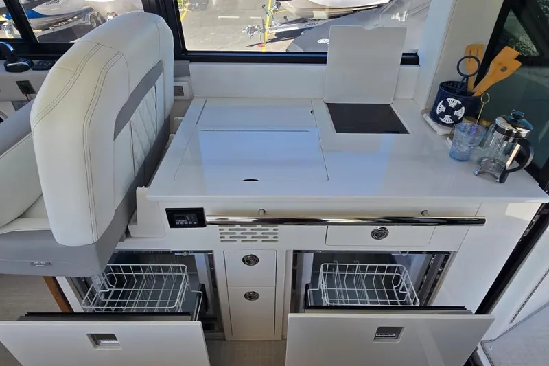Slide: The Image of 2024 Regal 36 XO yacht interior kitchen with modern appliances and sleek design. - 24