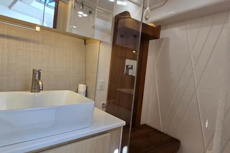 Slide: The Image of Modern bathroom interior of 2024 Regal 36 XO yacht, featuring sleek sink and wooden accents. - 27