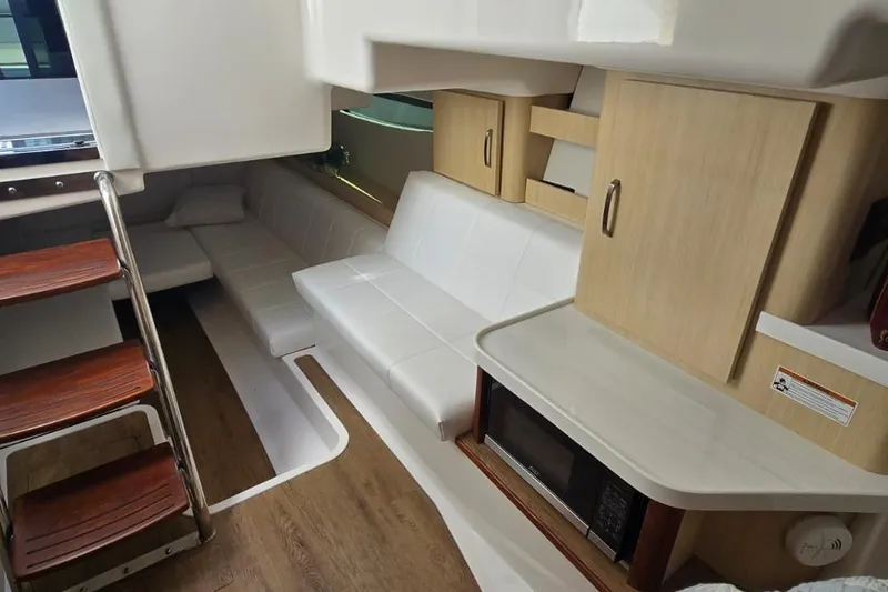 Slide: The Image of 2024 Regal 36 XO yacht interior with modern seating, wooden stairs, and cabinetry. - 30