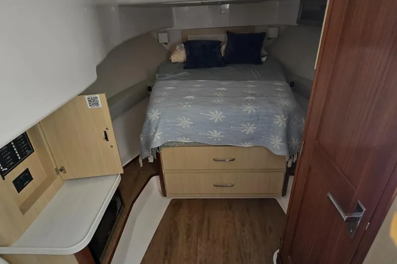 Slide: The Image of 2024 Regal 36 XO cabin interior with bed, storage, and wood accents. - 36